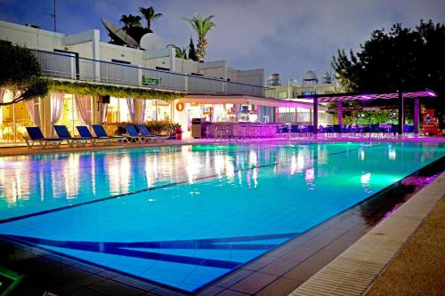 阿依纳帕Green Bungalows Hotel Apartments的夜间蓝色海水的大型游泳池