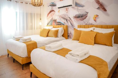 埃拉特YalaRent Ivy Villa with Private Pool的一间卧室配有两张带白色和黄色枕头的床