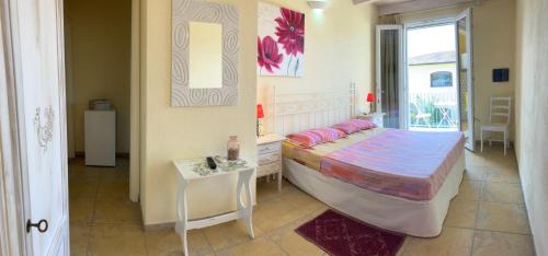 普拉Luigi Apartments&Rooms的一间卧室配有一张床、一张桌子和一个窗户。