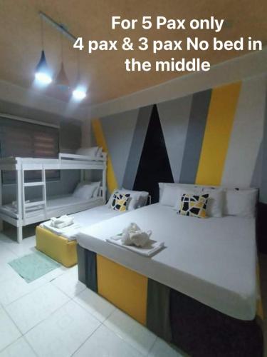 甲万那端DJCI Apartelle with kitchen n bath 105-104的一间客房配有两张床和一张双层床。