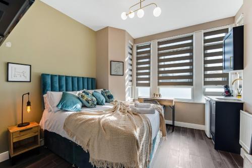 伦敦Elegant Studio - Perfect for Explorers的一间卧室配有一张蓝色床头板的床