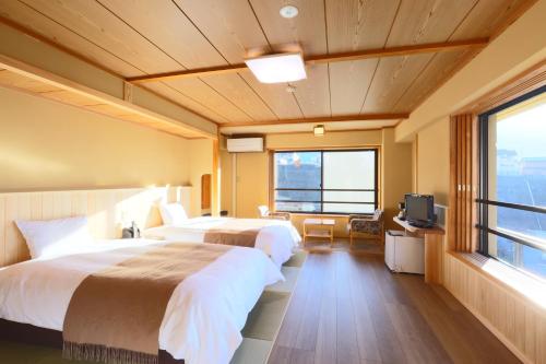 山之内町涩酒店的酒店客房设有两张床和电视。