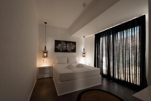 米科利维亚Villa Unica - Mikri Vigla, Seaview, Pool & Jacuzzi的卧室设有白色的床和大窗户