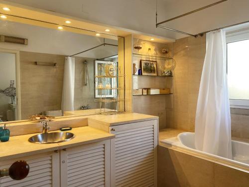 里斯本Casa das Boganvilias - Moradia com jardim的一间带水槽、浴缸和镜子的浴室