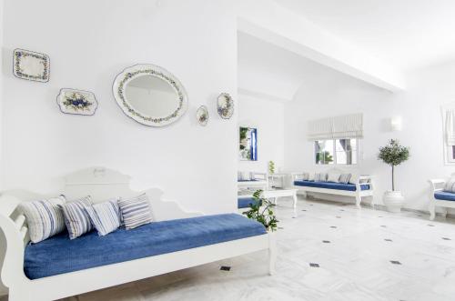 阿克罗蒂里天堂公寓式酒店的白色的客房设有一张床和墙上的镜子