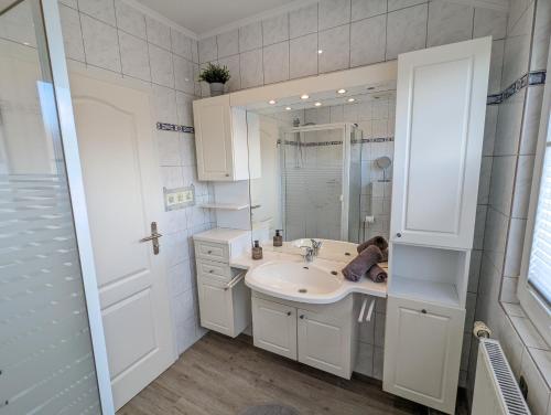 诺德代希Das Inselhaus的白色的浴室设有水槽和镜子