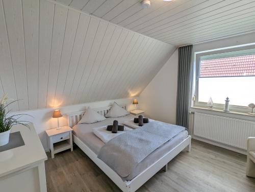 诺德代希Das Inselhaus的白色的卧室设有床和窗户