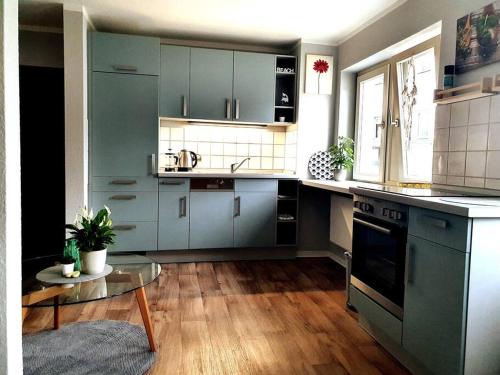 罗斯托克Rostock hautnah erleben - schöne Maisonette 2OG的厨房配有蓝色橱柜和桌子