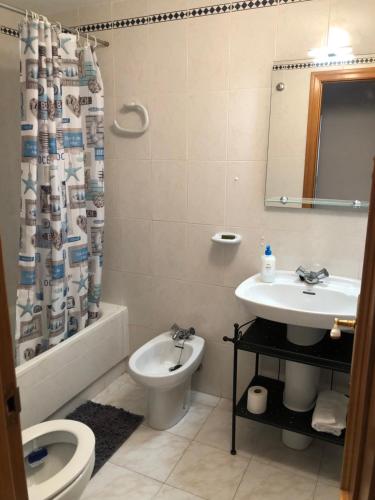 阿利坎特Precioso apartamento en Urbanización junto al mar.的浴室配有水槽、卫生间和浴帘
