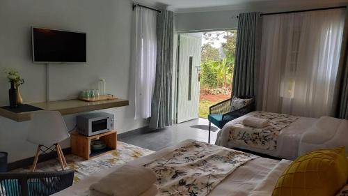SaganaKwetu Home - Sagana的客厅设有2张床和1台电视。
