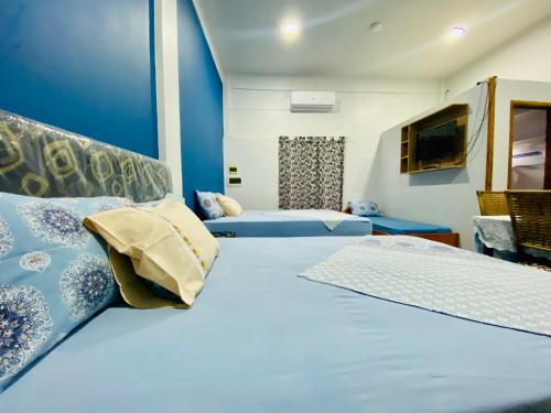 恩卡纳西翁SV Apart Hotel的一间卧室设有两张带蓝色墙壁的床