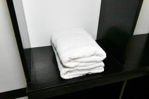 爱妮岛金丝燕酒店 的浴室内黑架上的白色毛巾
