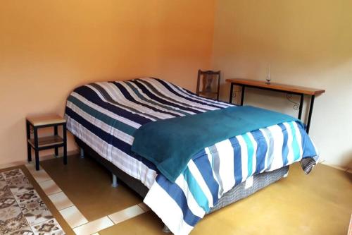 伊克斯雷玛Recanto do Ipê的一间卧室配有一张床,床上有条纹毯子