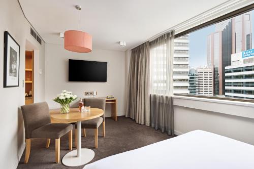 悉尼View Sydney的酒店客房设有一张桌子和一个大窗户。