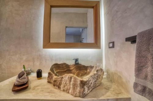 埃尔库约Hotel Boutique Can Cocal El Cuyo的浴室设有石质水槽和镜子