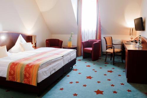 维斯马斯塔迪特·斯德姆酒店的酒店客房,配有一张床、一张桌子和椅子