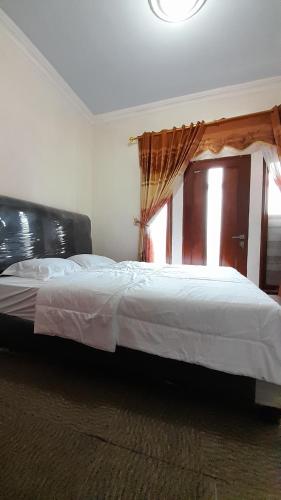 迪昂Homestay Merpati Dieng Syariah RedPartner的一间卧室设有一张大床和窗户