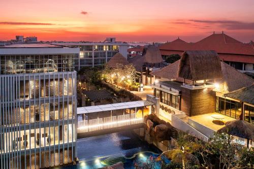 努沙杜瓦The Sakala Resort Bali All Suites的享有带游泳池的大楼的夜间景致