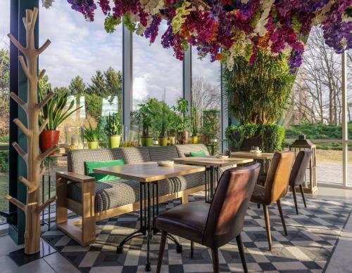 迭戈姆布鲁塞尔机场假日酒店的一间带桌椅和鲜花的餐厅