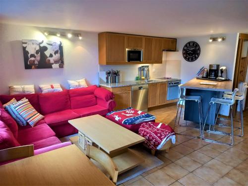 莱迪亚布勒雷Le Sapin的一间带红色沙发的客厅和一间厨房