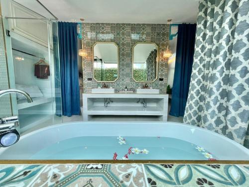 他朗基里别墅度假村的带浴缸、两个盥洗盆和镜子的浴室