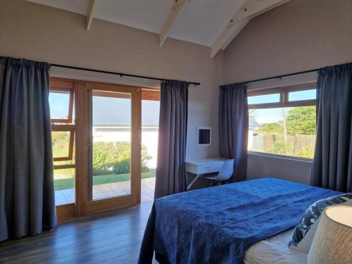钦查HERON COTTAGE - for your seaside holiday.的一间卧室设有蓝色的床和窗户。