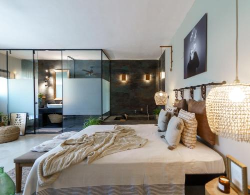 Bustan HaGalilגלילה - סוויטת בוטיק רומנטיות לזוגות עם האט טאב פרטי ליד הים的一间卧室设有一张带玻璃墙的大床