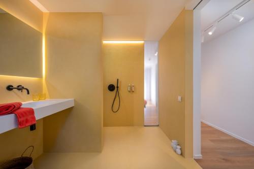 阿尔斯特Georges & Madeleine Apartments的浴室设有黄色的墙壁、水槽和淋浴。