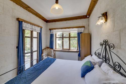 于尔居普埃尔蓬特洞穴酒店的一间卧室设有一张大床和两个窗户。