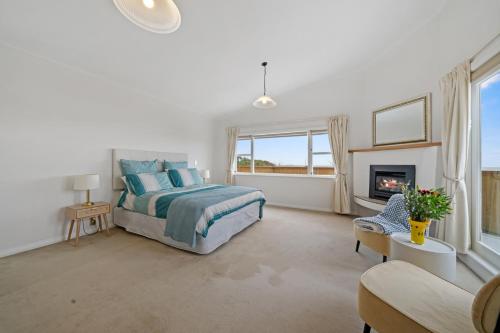 帕拉帕拉乌姆海滩Kapiti Getaway - Paraparaumu Beach Rental的一间卧室配有一张床和一个壁炉