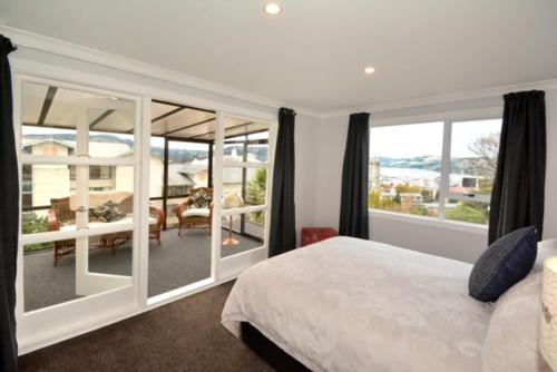 但尼丁City Views on Rattray的一间卧室配有一张床,享有庭院的景色