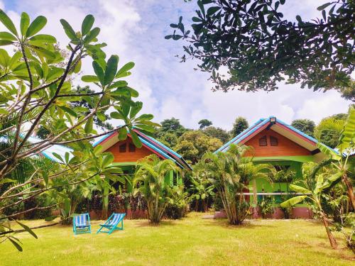 象岛Papaya Cottage Koh Chang的两栋房子,在院子前配有蓝色椅子