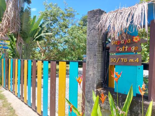 象岛Papaya Cottage Koh Chang的彩色的围栏,上面有读取快乐软骨的标志