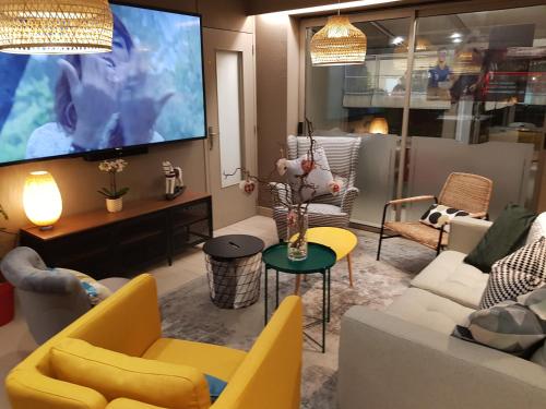 科尔马Campanile Colmar - Parc des Expositions的客厅配有电视和黄色家具。