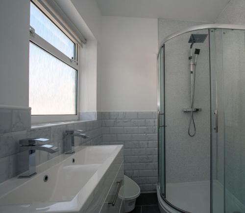 KentBotany Bay Holiday House - Family friendly, 50M from the beach的白色的浴室设有水槽和淋浴。
