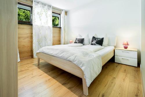 蒂罗尔-基希贝格Apartment Sunnyside Premium by Alpine Host Helpers的卧室配有一张白色大床和两个窗户
