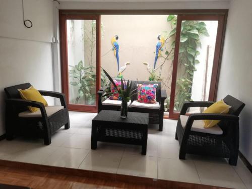 莱蒂西亚Tucuma Casa Hotel的客厅配有两把椅子和一张带花瓶的桌子
