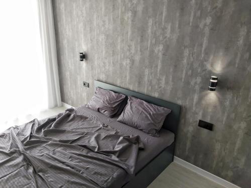 文尼察Люкс Апартаменты Gray Pearl на Подолье的卧室内的一张床位,卧室内有灰色的墙壁