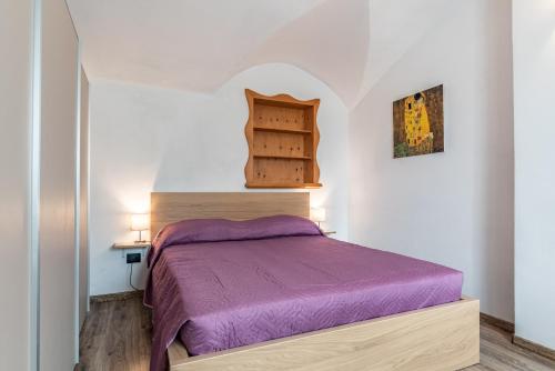 佩尔吉内瓦尔苏加纳Residenza Glicine的一间小卧室,房间内设有一张紫色的床