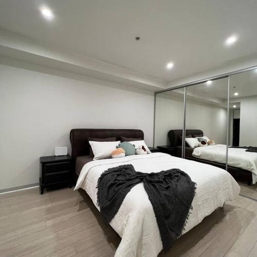 墨尔本Carlton Stunning View Apartment 150m away from University of Melbourne的一间卧室设有一张大床和一个大镜子