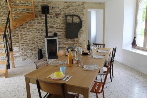 HamarsGîte Le Coq Au Vert en Suisse Normande的一间带木桌和壁炉的用餐室