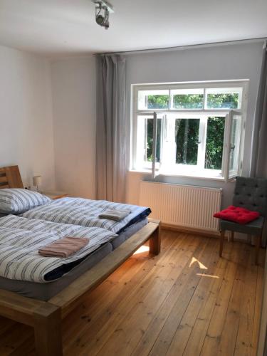慕尼黑Wohnung mit Charme的一间卧室设有一张床、一个窗口和一把椅子