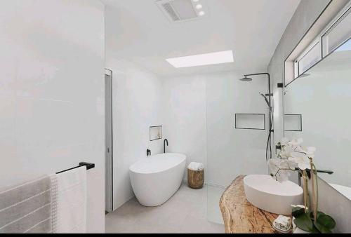 Chittaway PointLakeview House LILAC的白色的浴室设有浴缸和水槽。