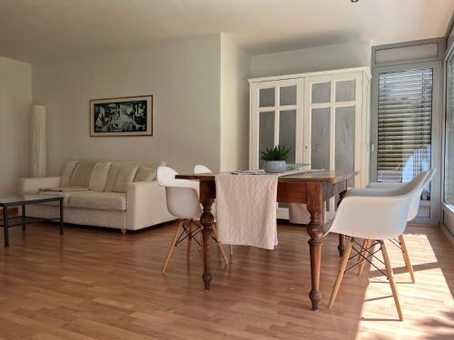 拉布拉Villa Maria的客厅配有木桌和白色椅子
