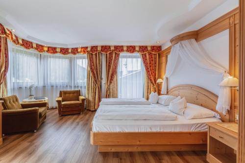 塞尔瓦迪加尔代纳山谷Garni Hotel Franca b&b的一间卧室配有一张大床和一把椅子