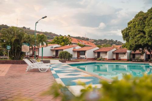 库库塔Hotel Faranda Bolivar Cucuta, a member of Radisson Individuals的一个带椅子和树木的度假村游泳池