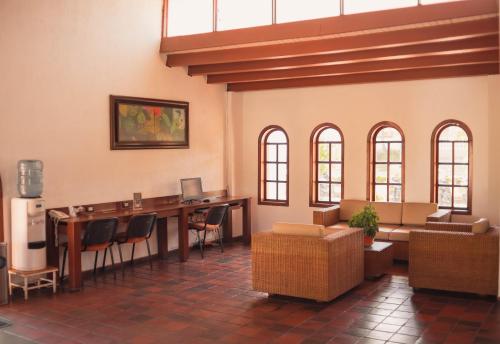 库库塔Hotel Faranda Bolivar Cucuta, a member of Radisson Individuals的大堂在房间内配有长桌子和椅子
