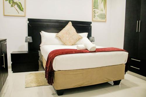 LobatsePitikwe Hill Guesthouse的一间卧室配有一张带黑色床头板的床