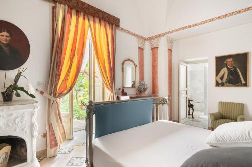 巴格里亚Vero Sicily - Sicilian Garden Cottages的一间卧室配有一张床和一个壁炉
