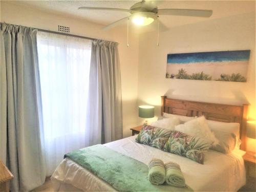 乌旺戈海滩Laguna La Crete 28的一间卧室配有一张带吊扇和窗户的床。